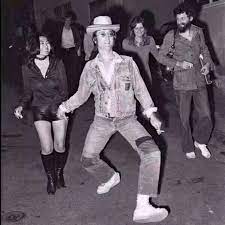 John Lennon doing a funky walk.