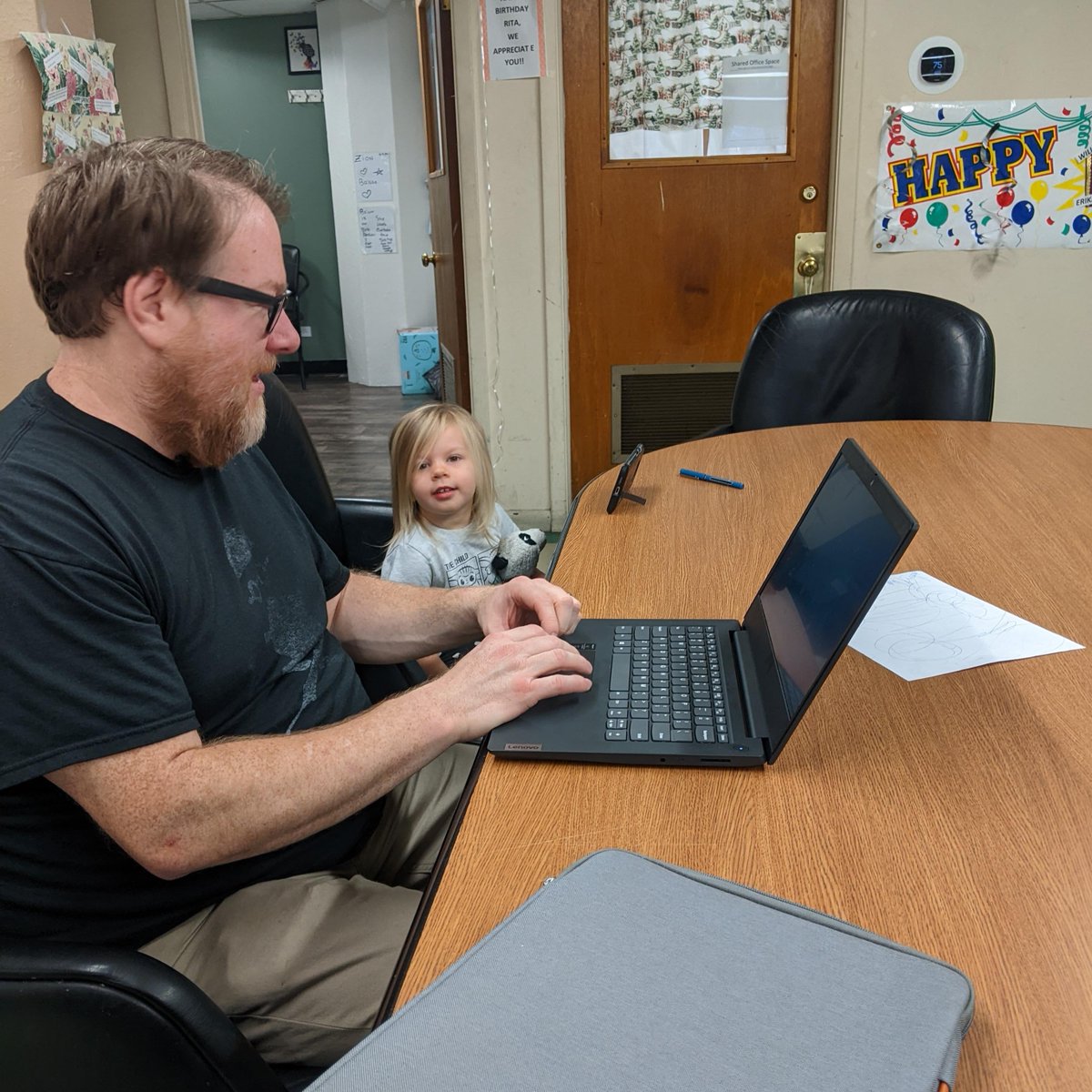 Future board member Miriam prepping for her Zoom meeting with Cocomelon while dad does some grant writing.