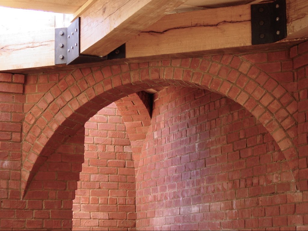 1000yearhouse's tweet image. Oak beams and iron work accompanying 
45° structural arches at Pierce Lee House in Rome, Georgia. I’ve always thought of brick as an incredibly expressive sculpting medium that is remarkably under-realized by the building industry and veneer jockeys of our day.