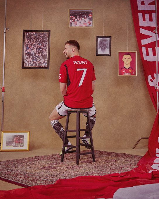 Mason Mount poses with his back to camera in United's new home kit to show his new #7 shirt.