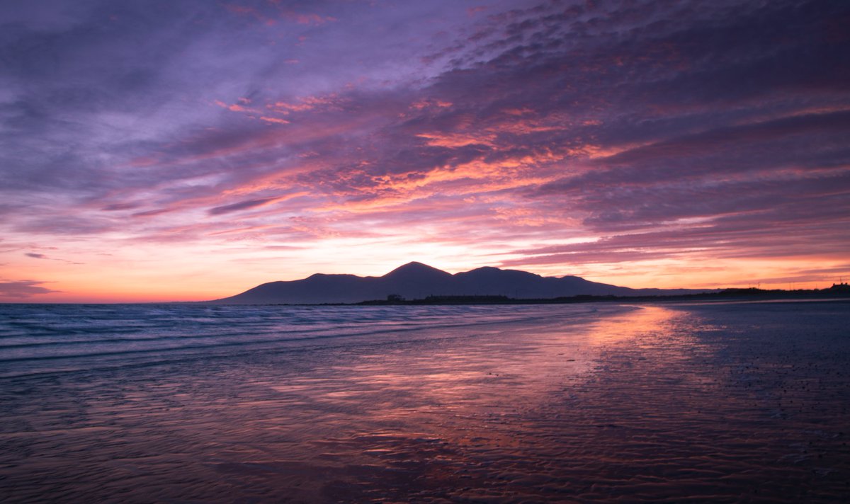 TheDarkPixel2's tweet photo. As the day drifts away, a mesmerizing sunset paints the sky, blending warm hues with serene waters. Majestic mountains watch from afar, completing the tranquil scene. #SunsetMagic #MountainSplendor #ireland #mournemountains https://t.co/H1OvunAJ3x