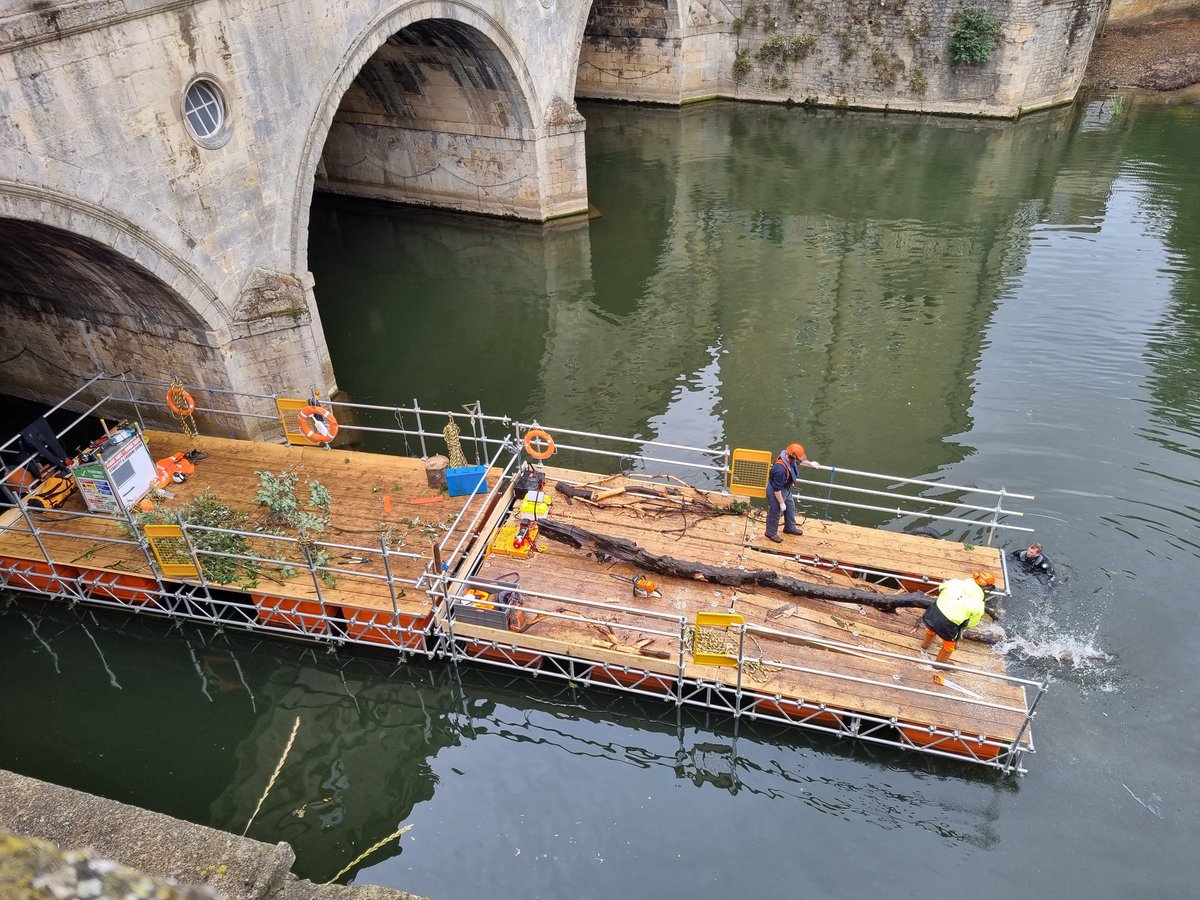 Recovering and sawing up floating timber debris at Pulteney Bridge, Bath