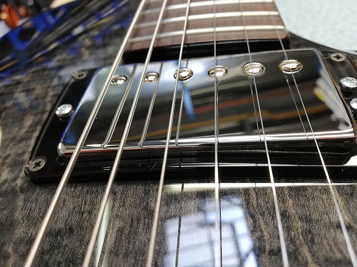Here's another thing we do on our guitars: Adjust the height of the humbucker pole piece screws. The reason is to balance the output level of each string.
Here, for a string set with a plain G, the G pole piece is lower than the E.
Why only few manufacturers do it?