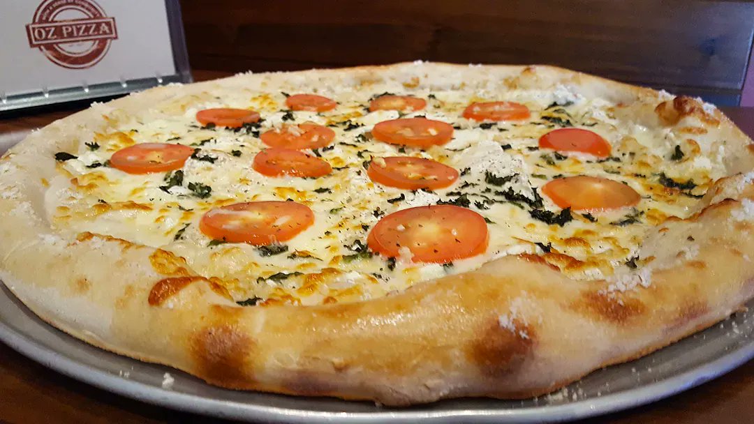 OzPizza's tweet photo. One of our delicious specialty pies, the White Pie. Topped with Ricotta cheese, fresh basil, Roma tomatoes, oregano, fresh garlic, black pepper &amp; mozzarella cheese. Delicious! #OzPizza #GoodEats https://t.co/8wFG3I6jCi