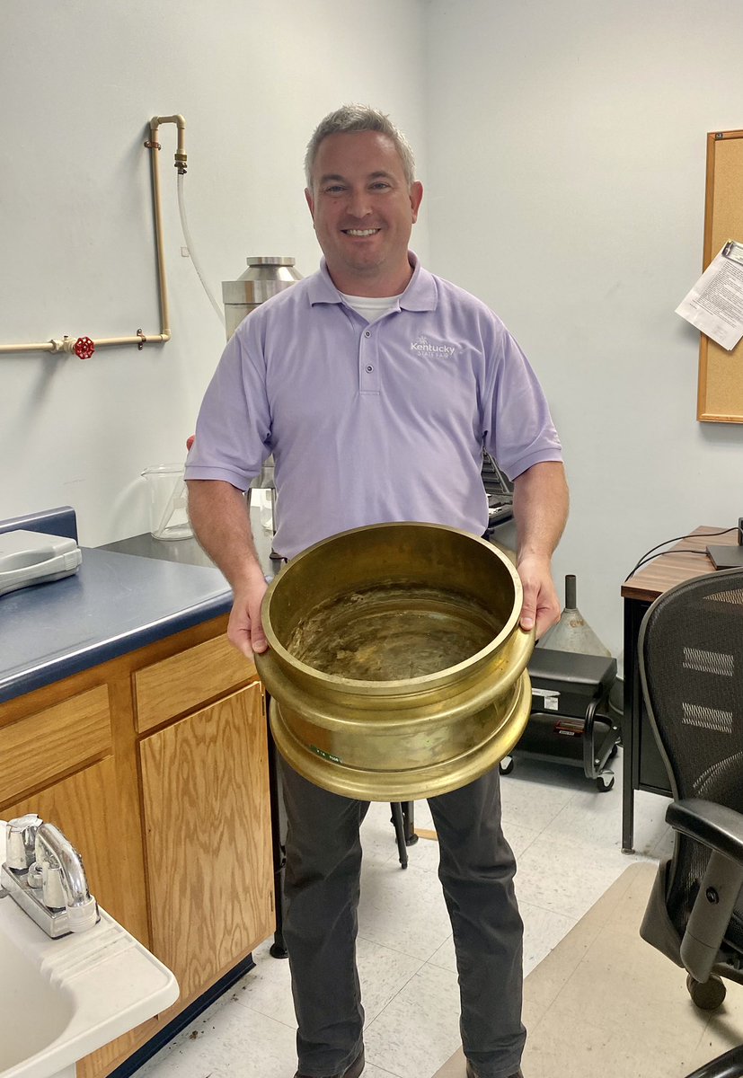 RyanQuarlesKY's tweet photo. Under lock and key are the official weights &amp; measures of our Commonwealth! Here lies the official 1 pound weight of Kentucky, in which all other scales are calibrated against. It’s so sensitive only medical gloves may be used on it. I’m holding the official half bushel and pint. https://t.co/chUjU0KbZY