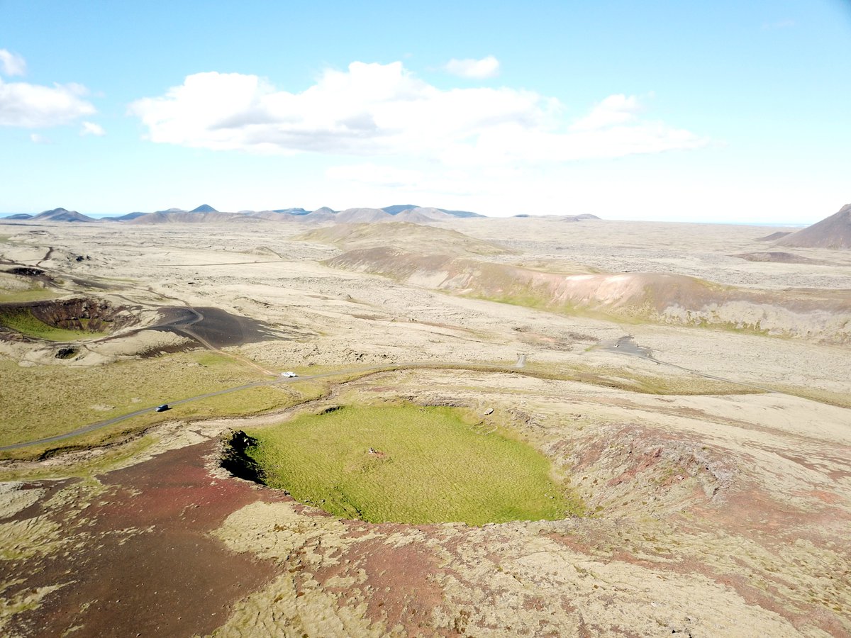 'Volcanic archaeology': a shieling in a crater at the forefront, with the 'mountain' formed in 2021/2022 eruption at Fagradalsfjall. A photo taken during a earthquake swarm that is likely a precursor of a new eruption expected in the incoming days #fornleifatwitter
