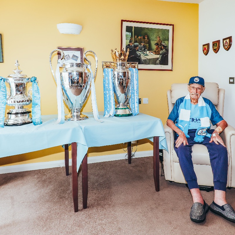ManCity's tweet photo. The first stop on our Treble Trophy Tour was to see 102-year-old City fan, Geoffrey! 🏆🏆🏆

Geoffrey has supported us since the 1920s and has seen every one of our league wins! 🩵