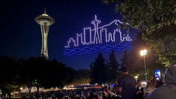 Drones form the shape of the Seattle Skyline in the air next to the Space Needle.