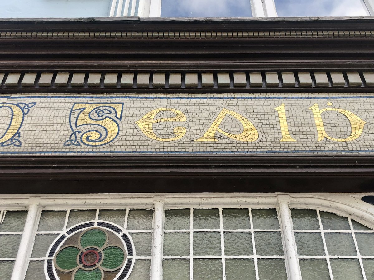 Mosaic tiled, decorative, gold #Gaelic letterforms at O Gealbháin, 21 William Street #Listowel #Kerry #Ireland (Images 1-8 31/07/22)   Built c1840, renovated c1920. Image 9 (17/11/2005) from #NIAH Reg No 21400257. Categories of Special Interest: Architectural, Artistic, Social.