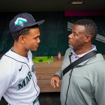 Ken Griffey Jr. speaks to Julio Rodríguez in the dugout before the Home Run Derby.