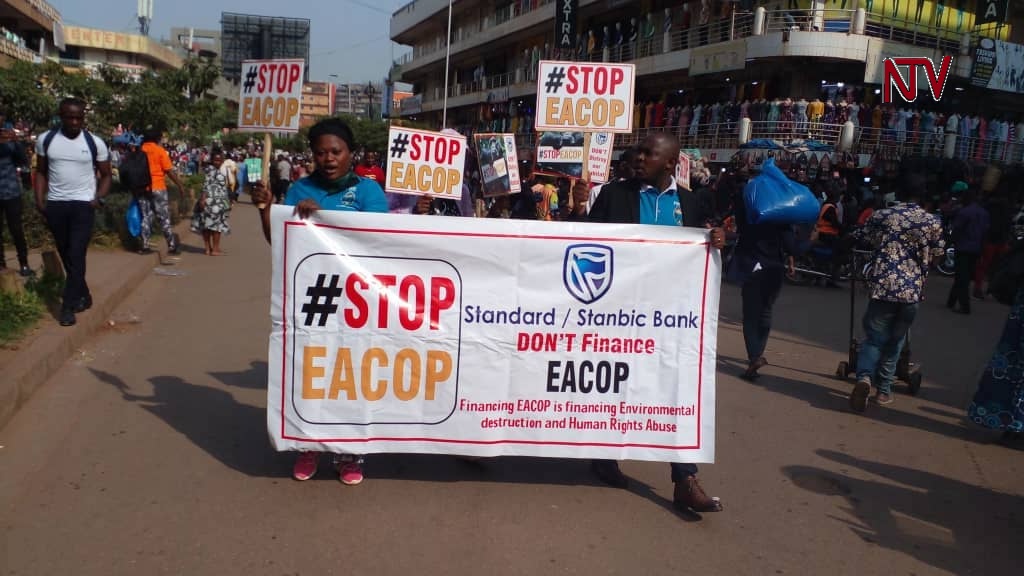 ntvuganda's tweet photo. Youth aligned with the FDC party are protesting against the EACOP project, demanding banks funding the project to halt. They claim the oil venture will escalate environmental devastation and human rights violations in Uganda. The protest happened in downtown Kampala. #NTVNews https://t.co/8fmpto3DwK