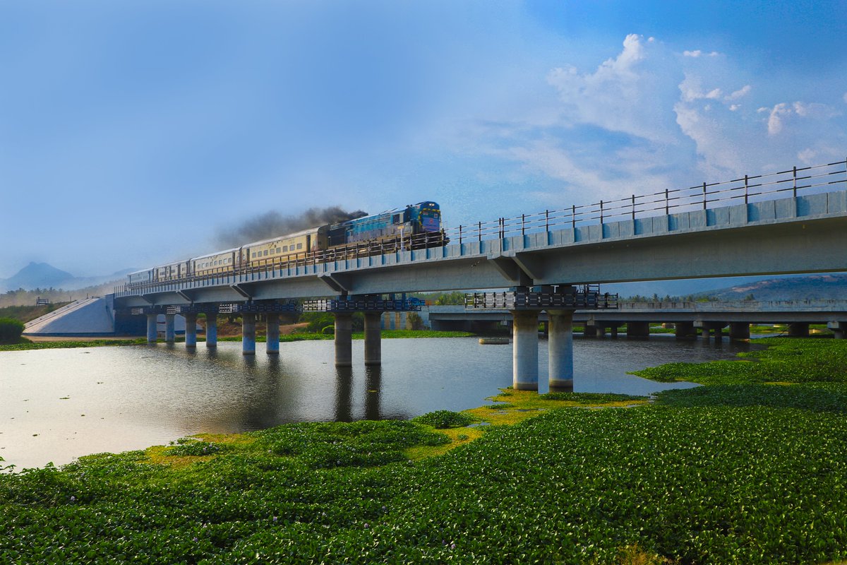 GMSRailway's tweet image. An awe-inspiring fusion of nature and engineering as the train gracefully crosses the Vaigai River Bridge. Witness the harmonious blend of clear blue skies, serene waters, and lush greenery on the mesmerizing Teni-Andipatti route. 
.
.
.
#SouthernRailway #ScenicView #VaigaiRiver