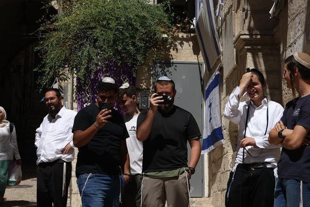 OnlinePalEng's tweet photo. Colonial Israeli settlers make fun of the Palestinian family Sub Laban and take photos provocatively of them after being forcibly displaced by Israeli occupation authorities from their own home in the Old City of occupied Jerusalem, today. https://t.co/HIgVwfnDMP