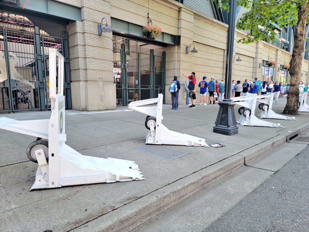 caseyworks's tweet photo. SPD officer says these temporary barriers were setup by Homeland Security and can stop a semi. Protecting people on sidewalks around the ballpark seems like a good idea not just this week but all the time. Black or dark green bollards could look better than these. https://t.co/mqXCrYgOoY