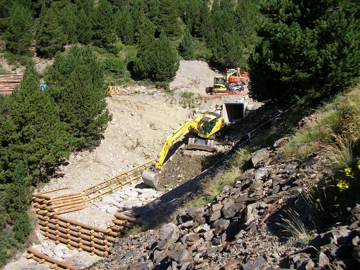 Protección de cauce aguas abajo de obra de drenaje de una vía mediante muro krainer y piedra.

📸 procedencia desconocida