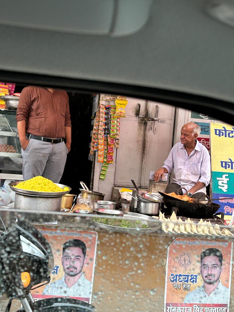It was raining heavily when I parked my car beside a traffic signal near court circle udaipur, where I saw an old uncle selling hot samosa and poha. I placed an order and curiously asked him why he didn't take a rest today, considering his age. He told me something that
