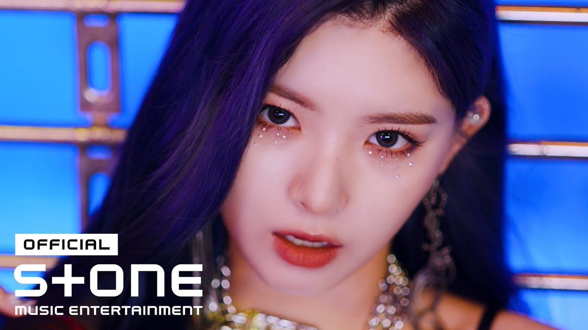 Close-up of a woman with purple hair and decorative rhinestones under her eyes, with 'OFFICIAL S+ONE music entertainment' branding in the corner.