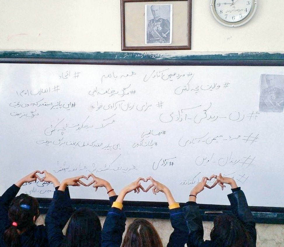 RBehrouzDO's tweet photo. Hijab-less high school girls in Iran bring down the photos of Ali Khamenei and Ruhollah Khomeini in their classroom and replace it with a picture of HIM Shah Mohammad Reza Pahlavi. Over a period of several months beginning in November 2022, schoolgirls across Iran were assailed with gaseous toxic chemicals, an act suspected to have been orchestrated by the IRGC. 
#شاهنشاه_روحت_شاد #پهلوی_سپاسگزاریم