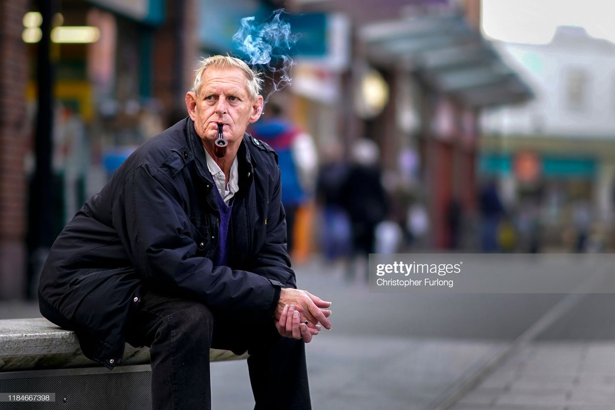 shitbritishpics's tweet photo. A man smokes a pipe as he sits in Workington town centre after a political think tank declared that politicians need to win the vote of 'Workington Man' in the next general election (2019) https://t.co/eQ3n1HeV8U