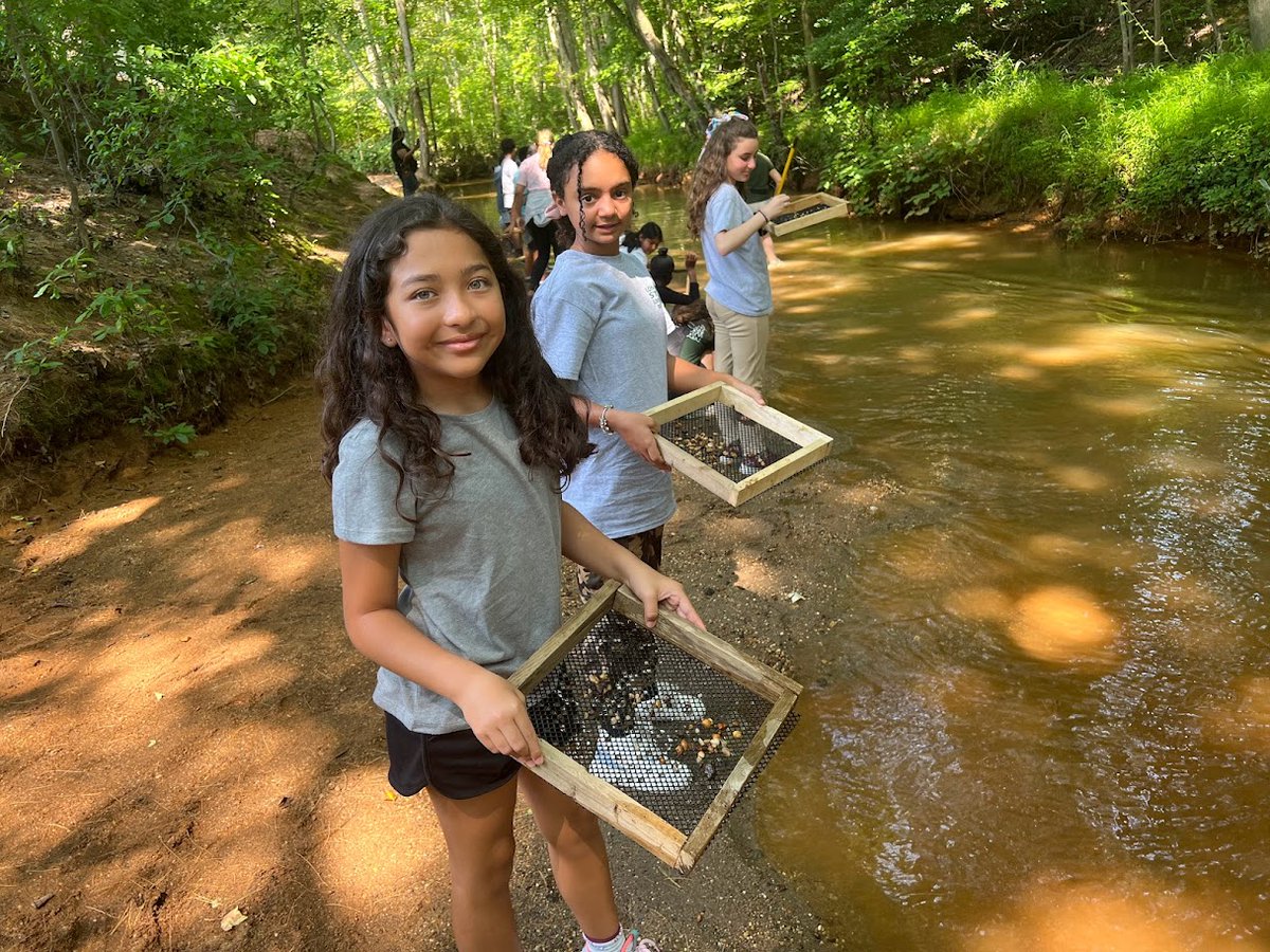 The stream at Shark River cuts through sediments that were deposited during the Late Eocene and Middle Miocene. Students are screening the gravel for fossils to identify shark teeth and the other fish, reptile, and mammal remains. <a href="/LBpublicschools/">Long Branch Public Schools</a>