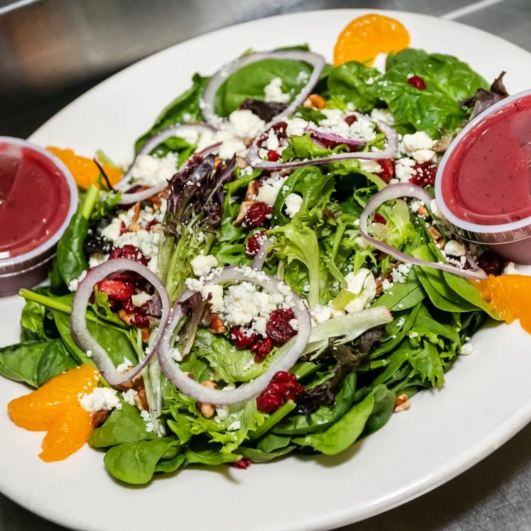 Complete with grilled chicken, spinach, dried cranberries, crushed pecans, blue cheese, mandarin oranges, red onions, and a raspberry vinaigrette, our cranberry pecan spinach salad is truly something special.