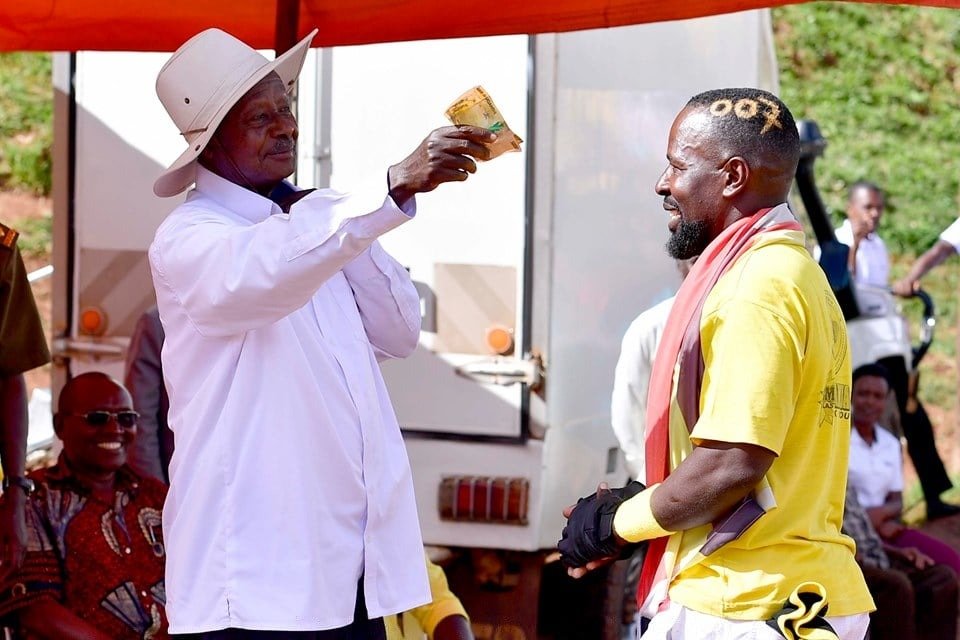 NellyKapo's tweet photo. President Museveni receives and appreciates Shs100,000 from Elijah Nsubuga. Nsubuga gave the money to Museveni and told him to use it to buy some "personal needs"; Airtime nga oyo, kikomando bwaba akyagade.. etc. FILE PHOTO. https://t.co/0sjlG6j5xf