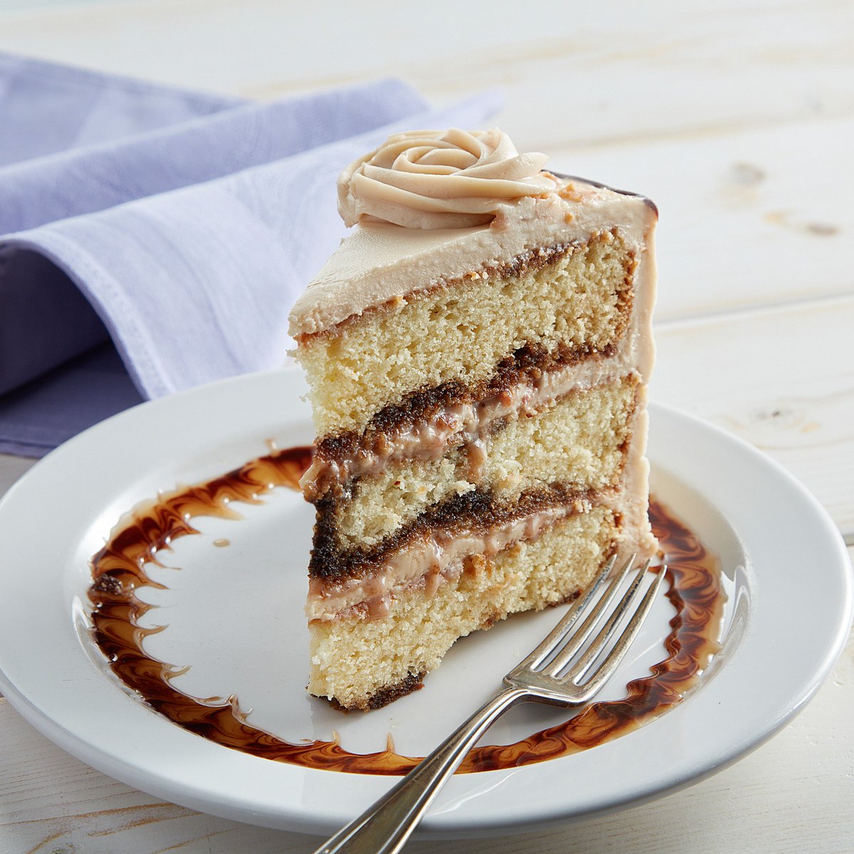 The Dessert Gallery Toffee-licious Cake: Yellow cake layers drizzled with espresso and filled with toffee bits and cream cheese frosting spiked with coffee liqueur. It's a coffee lover's dream. 🤩 ☕ Tag someone who needs to give this slice a try!