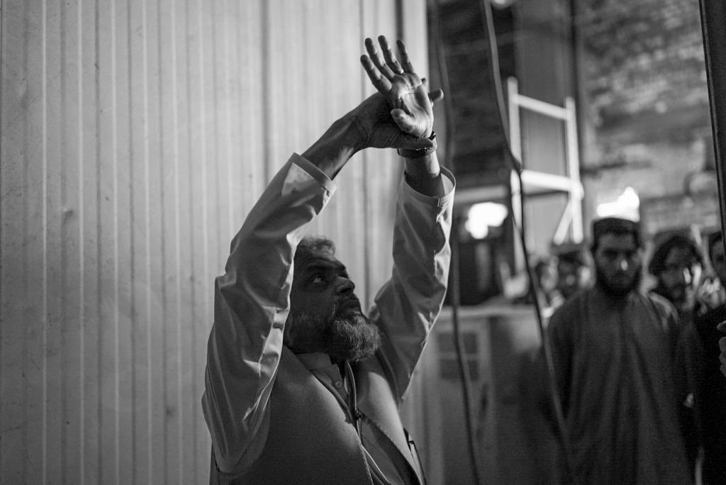 Moazzam_Begg's tweet photo. Images from my return trip to #Bagram #Afganistan

I’m describing how prisoners were hooded and their hands shackled above their heads to the cage door and punched and kicked. 

I’m explaining how an Afghan taxi driver by the name of Dilawar was beaten to death after being tied up like this for days and that image has been engraved in my head ever since.

I’m explaining how US soldiers would throw Qurans over cell doors when prisoners asked for them or drop kick the book like a football. When we first arrived soldiers ripped the Quran into pieces and threw them into buckets of excrement.

An American Egyptian interrogator told the US soldiers not to allow us to call the athan, recite the Quran or pray in congregation because that allowed to communicate with one another. If anyone did, they’d be tied up - just like Dilawar.

We had two small bottles of water per day. If we used them to wash or make wudhu we’d have nothing to drink. So most made tayammum. I did so for a year and forgot the correct sequence of wudhu by the time I arrived in #Guantanamo.

Despite this, I’m also telling them how I managed to memorise Surah Al-Baqarah - the largest chapter of the Quran - in this very spot. 

Im explaining how they’d built tiny one square metre isolation cells and kept us there for days on end during interrogation periods. 

I’m telling them about the screams of the woman I used to hear I thought was my wife; and how news of the birth of my son reached me here. 

Im retelling them how I saw all of this in a  vivid dreamI had 8 years before I came to Bagram.

I’m describing how British intelligence agents - who’d questioned me in UK several years before - came here many times and interrogated me while prisoners were screaming and tortured to death. 

Other than Guantanamo, I lived in this place away from home longer than anywhere else, so I knew it very well. 

This place is now abandoned and very dark - both physically and metaphorically. 

Returning here was an indescribable experience. I couldn’t help but to breakdown when recounting my thoughts and memories.

It’s no longer a torture facility but I did ask that IEA preserve some part of the place so that it’s never forgotten. They said they intend to do so but also they’d like to make it into a centre of learning, where young people can study for the future without forgetting the darkness of the past.

*Deepest gratitude to #Afghan former Bagram and #Gitmo  prisoners, families and very helpful #IEA officials for helping to make this happen. Images courtesy of @ShnizaiM. 

The film should be out in a few months  @AJEnglish #Witness in sha Allah. 

May Allah accept the efforts and sacrifices of all involved. 

الحمد لله حمدا كثيرا طيبًا مباركا