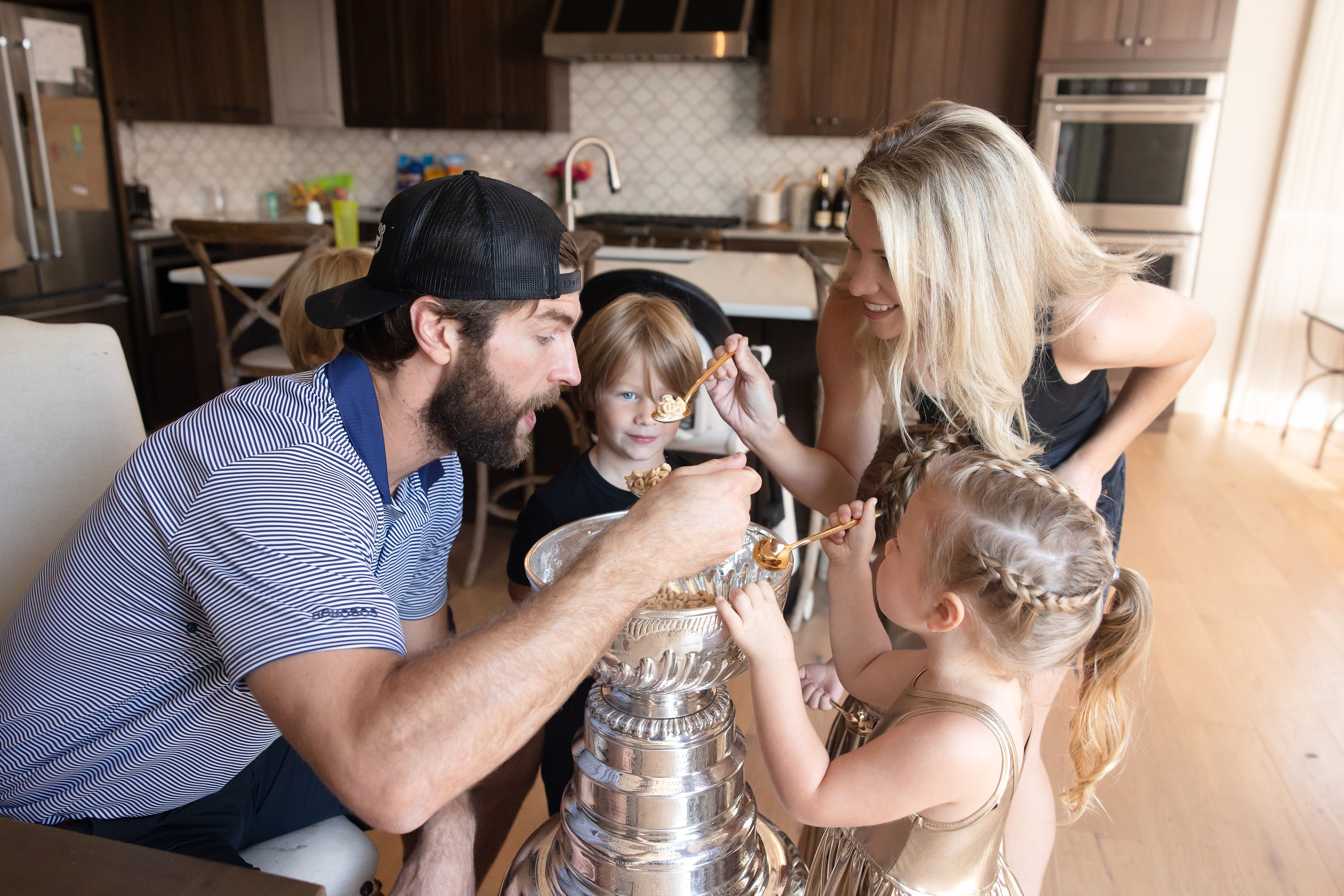 Alex Pietrangelo eats from the Stanley Cup with his wife and two children.