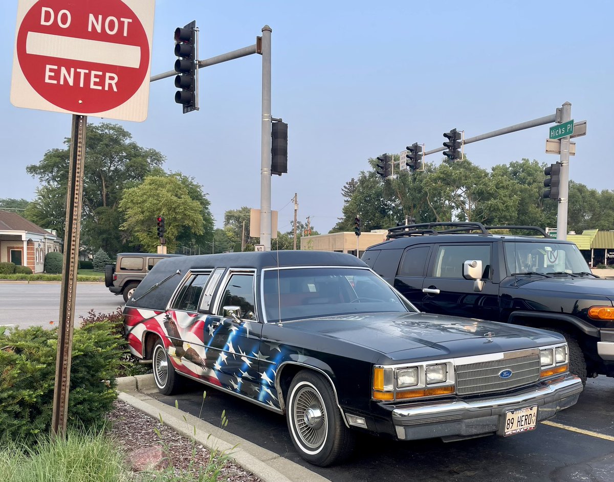 Car_Guy_Tom's tweet photo. It’s a patriotic hearse and mistreated Cavalier kind of Sunday. #CarSpotter #Ford #Hearse #Chevy #OverStickered #NASCAR https://t.co/gFtpwTF3uc