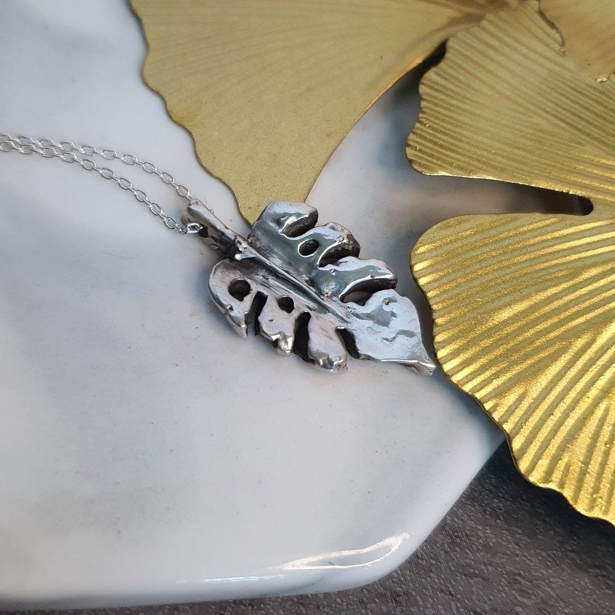 Embrace nature's beauty with our hand-carved Monstera Leaf Pendant. 🌿✨ Crafted from fine silver, its modern design captures the essence of the Monstera plant. Each piece is unique and comes with a complimentary 16" silver chain. Elevate your style today!  #HandcraftedJewelry