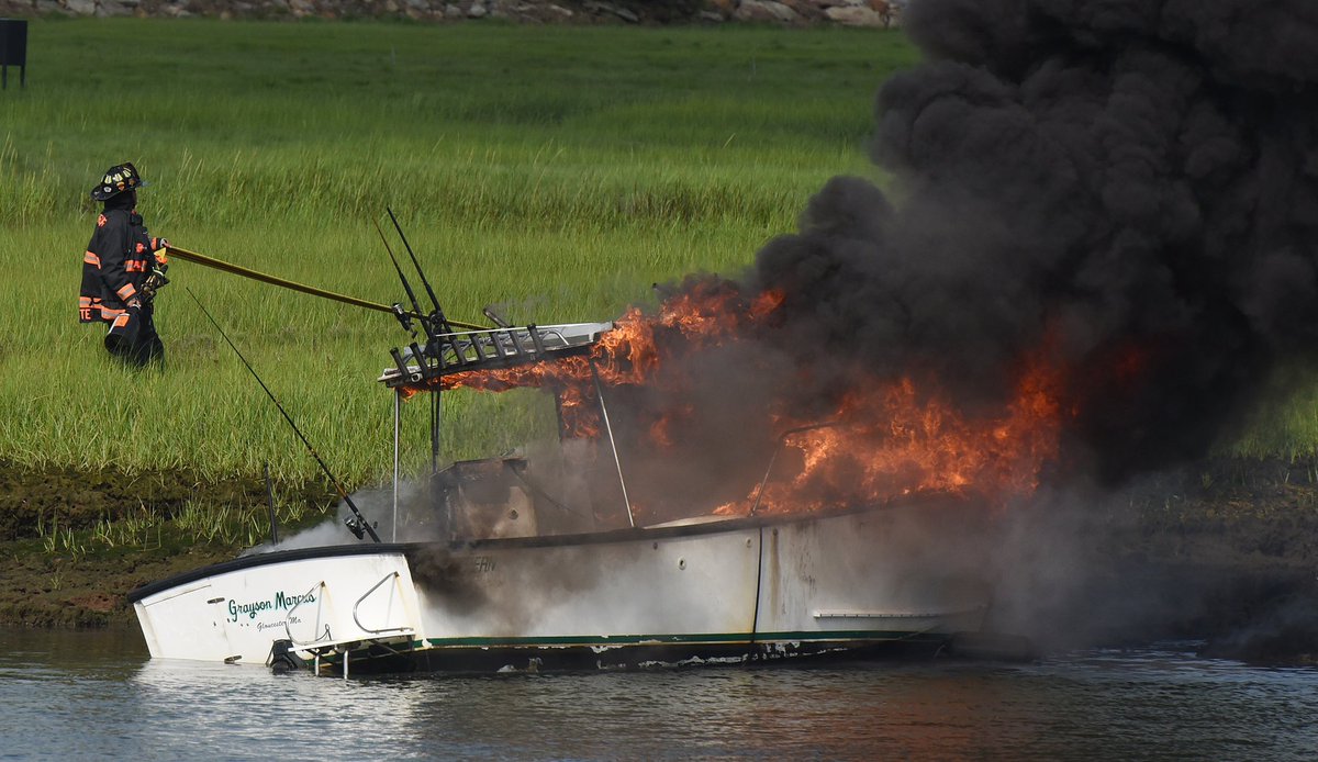 PHBPHOTO's tweet photo. Firefighters and Police use and foam to extinguish a boat fire in the Blynman Canal in Gloucester after it exploded sending two people into the water along with a dog, which was rescued by a boater. @GDTnews https://t.co/O5YqnUJheB