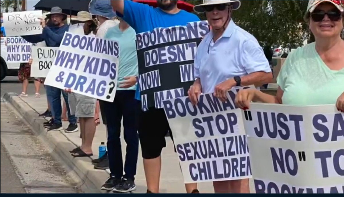 TheRealThelmaJ1's tweet photo. These idiots are standing in 110 degree heat in Tucson to protest Bookmans (a bookstore chain here)  bringing back drag story hour.  There are maybe 30 people out there all holding signs with IDENTICAL lettering though it is being reported as just concerned 'mama &amp; papa bears' https://t.co/fAAQoec9Fp
