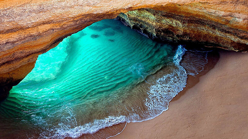 alentejo_1970's tweet photo. The Benagil Cave, or Algar de Benagil, is a natural cave resulting from years of sea eruption in sandstone rocks, which are mostly the composition of the coast of the region. The cave is located on the beach of the same name in the village of Carvoeiro, in the #Algarve https://t.co/7b8MV1fmT0