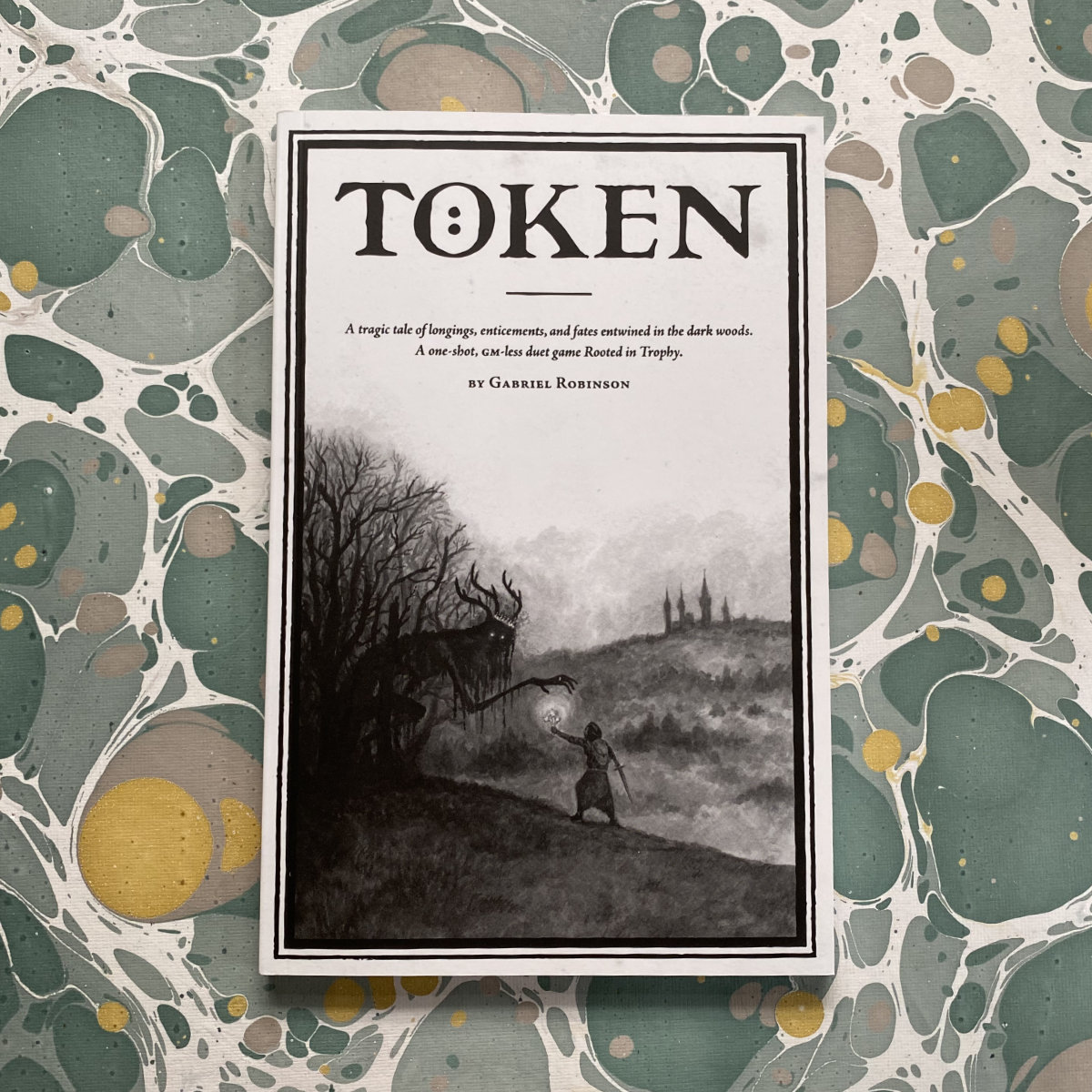 New in the shop: Token by <a href="/Glowing_Roots/">Glowing Roots Press</a> - a duet game for one failed hero, drawn inexplicably into the dark forest and one creature, once-human but now a wandering denizen of the haunted woods. Leave each other symbols, gifts, +signs of your intentions as you circle ever closer