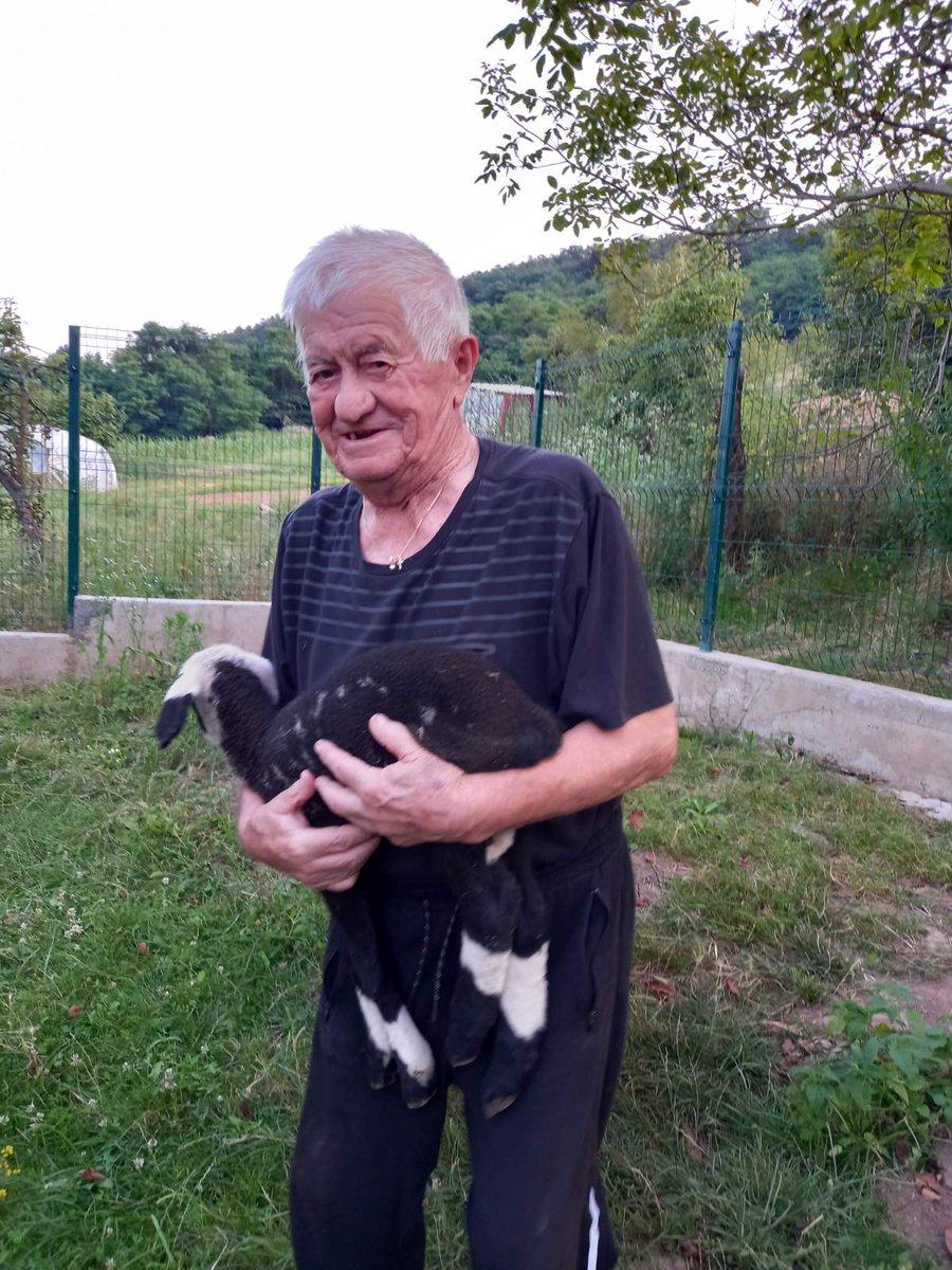 The youngest 87 year old in the world holding the lamb he just helped one of his sheep deliver.