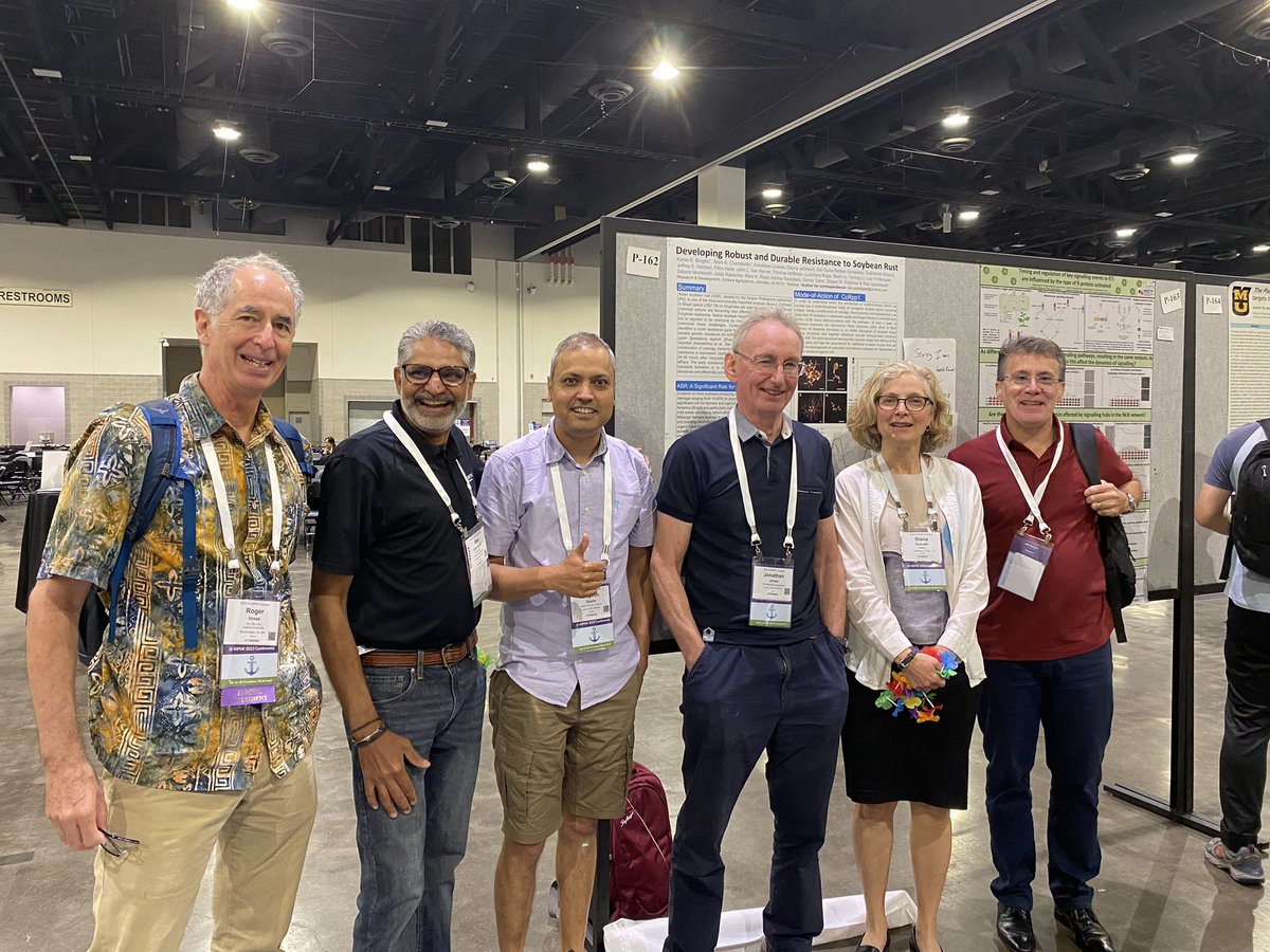 2blades's tweet photo. Several of the CcRpp1 team and @RogerInnes1, at a poster with the latest results from @uppalapati_rao including a great field shot of ASR resistant lines. Cheers to @2blades @ufvplantpath and @corteva colleagues who helped make the magic happen. #soybeanrust @PeterVanesse https://t.co/N2Qlzj4emu