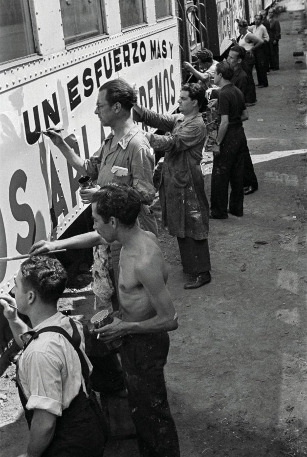 Membres del Sindicat de Dibuixants Professionals de Catalunya, pintant els trens amb propoganda antifeixista a l'estació de Sant Andreu, l’agost de 1936.