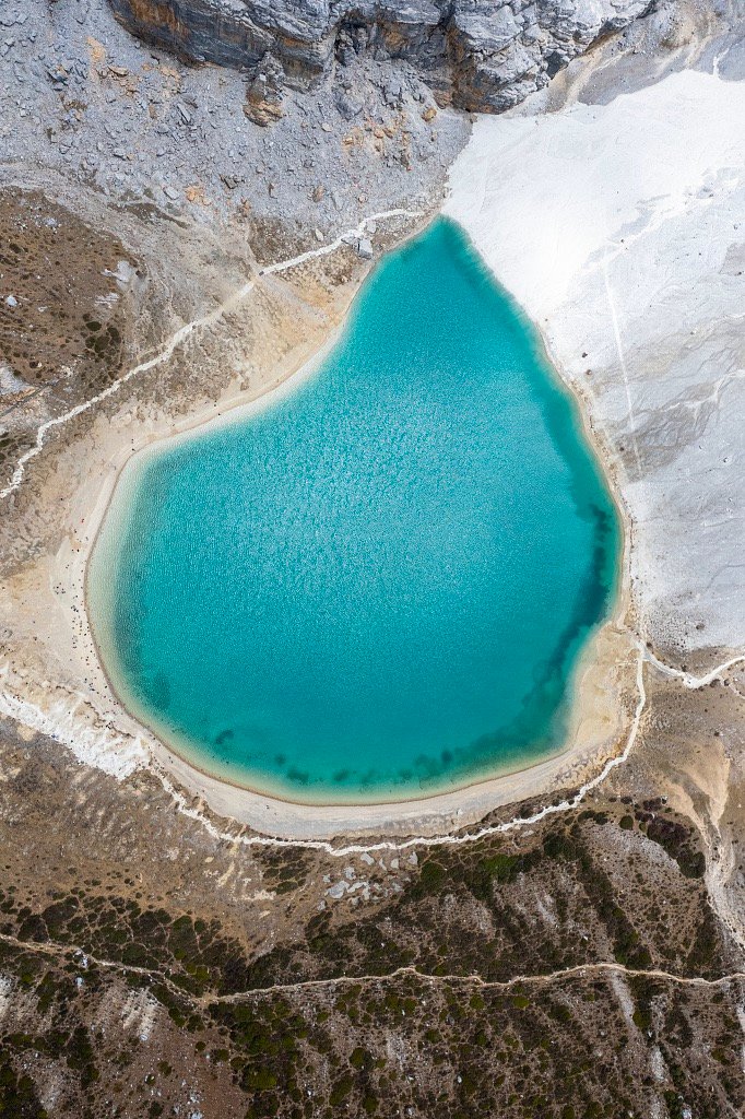 LoveYiwu's tweet photo. Surrounded by snow-capped mountains, the lake's crystal-clear blue waters and cascading waterfalls create a tranquil setting, earning its fame for the emerald-blue hues. #Yading https://t.co/vpCLhLOzwg
