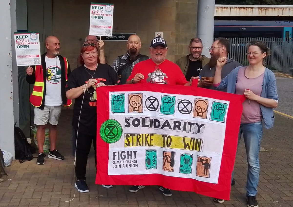 Solidarity to @RMTunion members on strike today for #FairPay, to defend jobs and oppose ticket offices closure. We call all @XRebellionUK groups to go and support Transport workers picket lines today, Saturday & 29th July. One of our banners on #Hastings picket ✊️💚