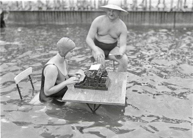 A businessman and secretary working in a pool during a heatwave in Berlin, Germany, 1926.