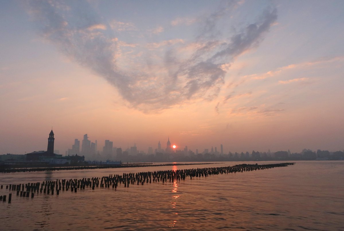 GaryHershorn's tweet photo. A hazy sky shrouds the sun as it rises behind the Empire State Building in New York City, Thursday morning #nyc #newyork #NewYorkCity #sunrise @agreatbigcity @empirestatebldg https://t.co/q8s767TpPd