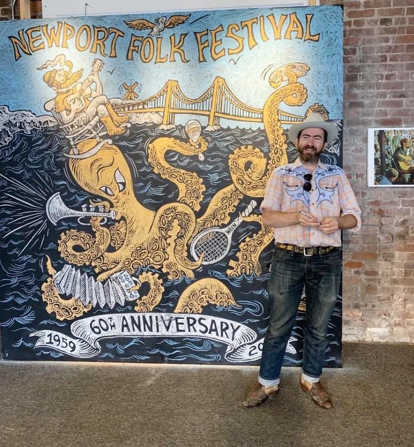 I had a wonderful conversation w/ Ken Abrams @WhatsUpNewp about my upcoming performance at @Newportfolkfest 'Fort Stage' (Main Stage) set on July 30th! whatsupnewp.com/2023/07/whats-… This pic Ken took of me standing in front of chalkboard art I made for #NewportFolkFestival years ago!