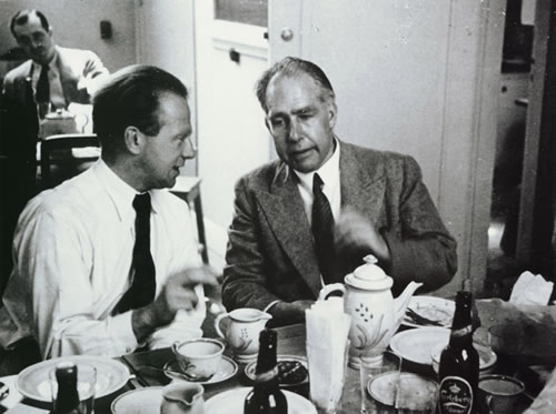 Quantum physicists Niels Bohr and Werner Heisenberg having a discussion over something while having what seems to be tea (or beer)