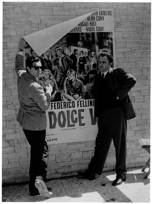 artribune's tweet photo. #fotodelgiorno: Federico #Fellini e Marcello Mastroianni davanti alla locandina del film #ladolcevita https://t.co/Q6g3rIwEig