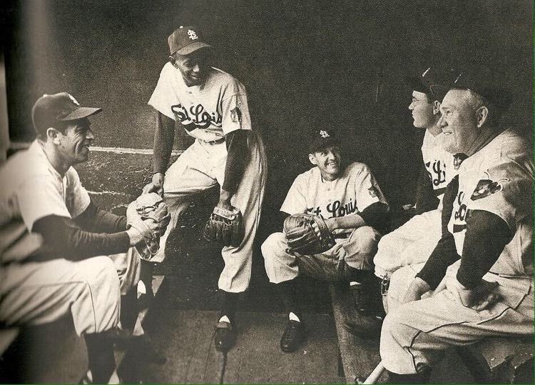 ouroldballgame's tweet photo. Satchel Paige chats with teammates and manager Rogers Hornsby before a game, 1952. https://t.co/jW5Wk031tt