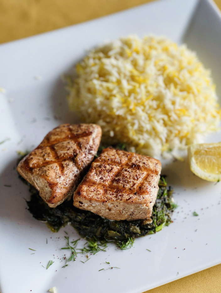 When it's hot outside it can be hard to find a meal that makes you feel good. This salmon entree is light, refreshing, healthy and a great summer option! With the marinated and charbroiled salmon, you will also enjoy our slowly cooked greens and saffron basmati rice.