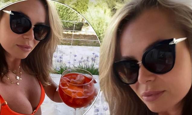 Amanda Holden, 51, sends temperatures soaring in a skimpy orange bikini as she enjoys a cocktail during romantic getaway with husband Chris Hughes https://t.co/ILbM3TEjHj https://t.co/zGd9JE3899