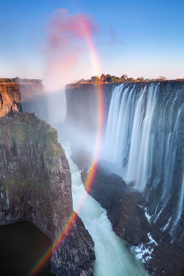 Vertical rainbow. The sun rose this morning at 6:47am over the Zambezi River's Mosi-oa-Tunya (which non-Africans have been calling Victoria Falls for some reason) separating Zambia from Zimbabwe, and the sun's first rays make a prism of the water's mist. Have a glorious Sun(day)!