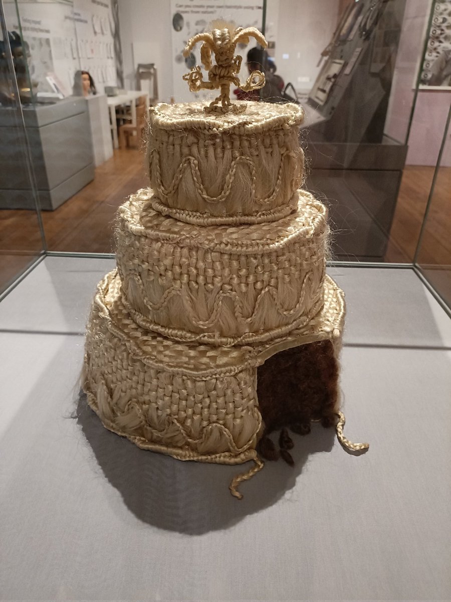 immaterial_me's tweet photo. Antidote to all things Barbie - Hair: Untold Stories from @HornimanMuseum currently @SheffMuseums 
Right to left: human hair Victorian wedding cake (perhaps for widower?), WW1 German ad for hair donations to make transmission belts for submarines, blond hair dress by @JenniDutton https://t.co/GsSUfxHyGO